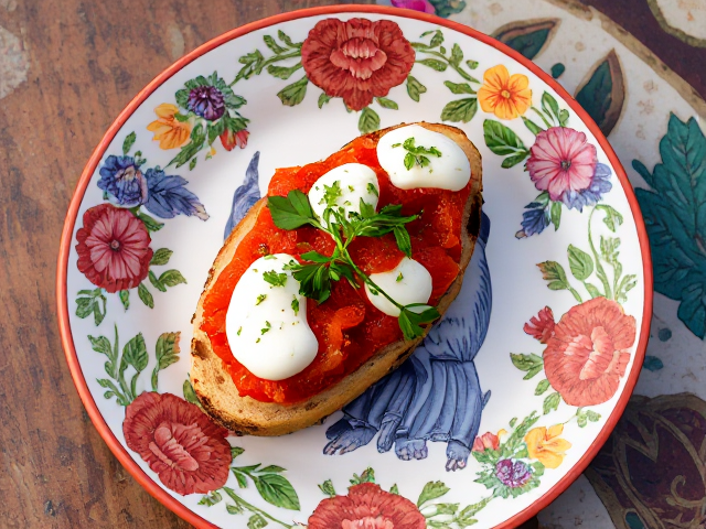 3 Colorful, floral ceramic plate with una bruschetta pomodorro e mozzarella. Location: Terrace in Sicily.