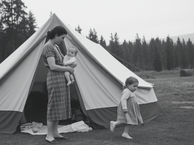 1940 tent camping and mother standing holding baby and young girl running to mother