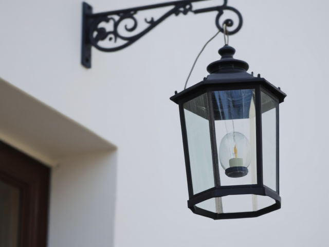 A classic lantern hanging from a wall hook.